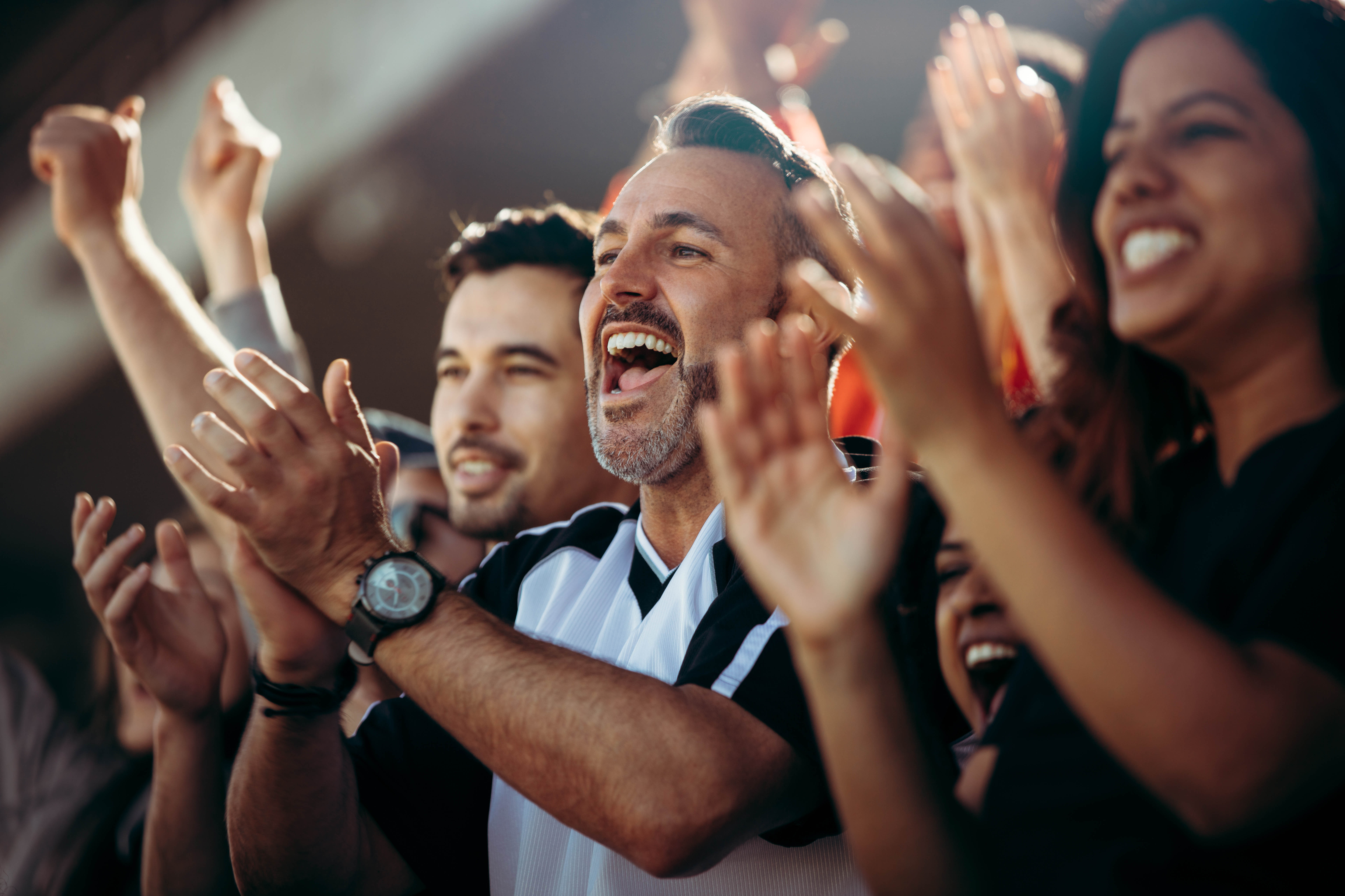 Diverse crowd of people cheering and applauding at a sports event Diverse crowd of people cheering and applauding at a sports event